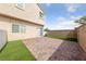 Fenced backyard featuring a brick patio and faux grass, plus a sliding door entrance to the home at 9312 Straw Hays St # 103, Las Vegas, NV 89178