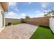 Fenced backyard with a brick patio and faux grass, creating a charming outdoor space at 9312 Straw Hays St # 103, Las Vegas, NV 89178