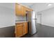A stainless steel refrigerator with wooden cabinets and dark-colored flooring at 9312 Straw Hays St # 103, Las Vegas, NV 89178