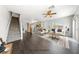 Staged living room featuring dark floors, stairs, a ceiling fan, and neutral-colored furniture at 9312 Straw Hays St # 103, Las Vegas, NV 89178