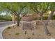 Breckenridge community entrance with stone wall, trees, landscaping, and brown planter at 9792 Crescent Lodge Ct, Las Vegas, NV 89178