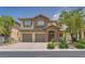 Charming two-story home featuring a stone facade, well-maintained landscaping, and a three-car garage at 9792 Crescent Lodge Ct, Las Vegas, NV 89178