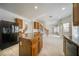 Open-concept kitchen with granite counters, an island, maple cabinets, stainless appliances, and tile floors at 9792 Crescent Lodge Ct, Las Vegas, NV 89178