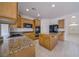 Spacious kitchen with granite countertops, maple cabinets, an island, and tile flooring at 9792 Crescent Lodge Ct, Las Vegas, NV 89178