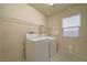 Functional laundry room featuring tile floors, storage shelf, and included washer/dryer at 9792 Crescent Lodge Ct, Las Vegas, NV 89178