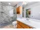 Bathroom featuring marble shower with grab bar, oak vanity, and tile flooring at 9962 Keephills St, Las Vegas, NV 89183
