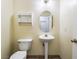 Cozy half bathroom with a pedestal sink, toilet, and a small storage shelf at 9962 Keephills St, Las Vegas, NV 89183