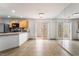 Bright open-concept kitchen with stainless steel appliances, a mirrored wall, and sliding glass door to the outside at 9962 Keephills St, Las Vegas, NV 89183