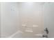 Shower featuring white tiles and built-in shelving at 9962 Keephills St, Las Vegas, NV 89183