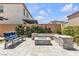 Inviting backyard with stone-clad fire pit and ample seating on a paved patio, perfect for outdoor entertaining at 10300 Stroma Ave, Las Vegas, NV 89166