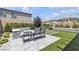 Charming backyard with cozy fire pit, seating area, lush greenery, and in-ground jacuzzi for outdoor relaxation at 10300 Stroma Ave, Las Vegas, NV 89166