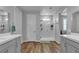 Modern bathroom featuring a glass enclosed shower, double vanity and wood flooring at 10300 Stroma Ave, Las Vegas, NV 89166