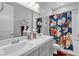 Elegant bathroom with double sinks, quartz countertop, tub and colorful shower curtain at 10300 Stroma Ave, Las Vegas, NV 89166