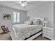 Bright bedroom with white furniture, floral bedding, wood-look flooring, and natural light from the window at 10300 Stroma Ave, Las Vegas, NV 89166