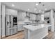Spacious kitchen featuring an island, stainless steel appliances, stylish pendant lighting, and marble countertops at 10300 Stroma Ave, Las Vegas, NV 89166