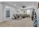 Open living room with comfortable sofas, ceiling fan, and access to another room at 10300 Stroma Ave, Las Vegas, NV 89166