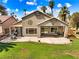 An outdoor patio area has a seating area, and a spacious backyard with green grass and desert landscaping at 1131 Golf Club, Laughlin, NV 89029