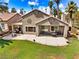 A outdoor patio area has a seating area, and a spacious backyard with green grass and desert landscaping at 1131 Golf Club, Laughlin, NV 89029