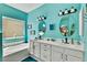 Bright bathroom features dual sinks, mirrors, garden tub, and turquoise accent wall at 1131 Golf Club, Laughlin, NV 89029