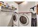 Neat laundry room with shelving, hanging rack, and a set of front load washer and dryer at 1131 Golf Club, Laughlin, NV 89029