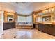 Luxurious primary bathroom showcasing a soaking tub, glass block window, and dual sink vanities at 1235 Panini Dr, Henderson, NV 89052