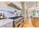 Modern kitchen with a large stainless steel range, pot filler, and bright lighting fixtures at 1235 Panini Dr, Henderson, NV 89052