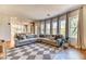 Spacious living room featuring hardwood floors, a large sectional sofa, and multiple windows for natural light at 1235 Panini Dr, Henderson, NV 89052