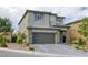 Two-story home featuring desert landscaping, a paver driveway, and a two car garage at 12426 Alpenglow Ct, Las Vegas, NV 89138