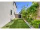 This side yard features artifical turf and lush green landscaping along the fence at 12426 Alpenglow Ct, Las Vegas, NV 89138