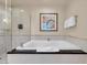 Elegant bathroom featuring a glass-enclosed shower and a luxurious soaking tub with marble tile at 125 E Harmon Ave # 511, Las Vegas, NV 89109