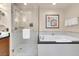 Elegant bathroom featuring a glass-enclosed shower and a luxurious soaking tub with black marble countertop at 125 E Harmon Ave # 511, Las Vegas, NV 89109