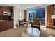Bright living room featuring a kitchenette, sitting area, desk, and large windows with city views at 125 E Harmon Ave # 511, Las Vegas, NV 89109