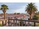 View of the backyard featuring palm trees and a red-tiled roof from an elevated deck at 1251 Los Meadows Dr, Las Vegas, NV 89110