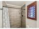 Modern bathroom with tiled shower and wood-framed window at 1251 Los Meadows Dr, Las Vegas, NV 89110