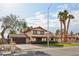 Beautifully landscaped home with lush green lawn, mature palm trees, and a spacious driveway leading to a garage at 1251 Los Meadows Dr, Las Vegas, NV 89110