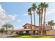 Well-maintained home with a tiled roof, mature palm trees, and lush green lawn, showcasing curb appeal under a sunny sky at 1251 Los Meadows Dr, Las Vegas, NV 89110