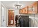 Laundry room with wood cabinets and black washer/dryer units at 1251 Los Meadows Dr, Las Vegas, NV 89110