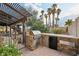 Outdoor kitchen area with built-in grill and brickwork, adjacent to a landscaped patio area at 1251 Los Meadows Dr, Las Vegas, NV 89110