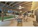 Covered outdoor patio with ceiling fan, ample seating, manicured lawn, and lush landscaping at 1251 Los Meadows Dr, Las Vegas, NV 89110