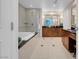 Bathroom featuring a soaking tub, walk-in shower with glass enclosure, and modern vanity with ample counter space at 135 E Harmon Ave # 1621, Las Vegas, NV 89109