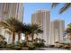 An eye-level exterior view of the Signature at MGM Grand towers, framed by palm trees and sunny sky at 135 E Harmon Ave # 1621, Las Vegas, NV 89109