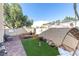 Enjoy outdoor living in this backyard with artificial turf, doghouse, shade tree and a swing at 1502 Oxbow Ct, Henderson, NV 89014