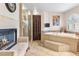 Bathroom featuring fireplace, soaking tub, walk-in shower and natural light at 1502 Oxbow Ct, Henderson, NV 89014