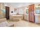 Bright bathroom with a luxurious soaking tub, tiled floor, and a glass shower at 1502 Oxbow Ct, Henderson, NV 89014