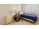 Cozy bedroom with a blue bedspread, a side table, and a window offering a comfortable and serene space at 1502 Oxbow Ct, Henderson, NV 89014