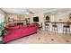 Open-concept living room with a fireplace, bar area, and tile flooring for easy maintenance at 1502 Oxbow Ct, Henderson, NV 89014