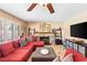 Comfortable living room features a red sectional, fireplace and mantle, and tile flooring at 1502 Oxbow Ct, Henderson, NV 89014