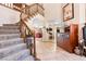 Spacious foyer featuring a carpeted staircase, tile flooring, and an open layout to the living areas at 1502 Oxbow Ct, Henderson, NV 89014