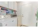 Bright laundry room features a washer, dryer, and white storage shelves at 1513 Brocado Ln, Las Vegas, NV 89117