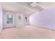 Spacious living room with light purple walls, fireplace, carpeted floors, and natural light from windows at 1513 Brocado Ln, Las Vegas, NV 89117